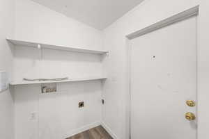 Laundry area featuring dark wood finished floors, electric dryer hookup, and ornamental molding