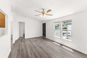 Spare room featuring ornamental molding, light wood-style floors, ceiling fan, and lofted ceiling