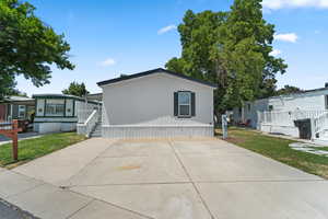 Manufactured / mobile home featuring a front lawn and a patio area
