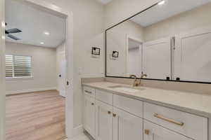 Bathroom with recessed lighting, vanity, and light wood-type flooring