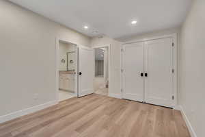 Unfurnished bedroom featuring recessed lighting, light wood-style floors, a closet, and connected bathroom