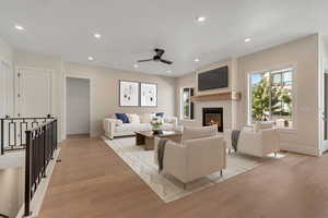 Living area featuring light wood finished floors, recessed lighting, a fireplace, and ceiling fan