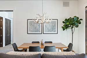 Dining room with carpet flooring and a chandelier