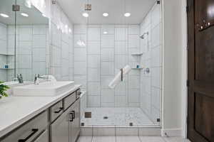 Full bathroom featuring a shower stall, vanity, recessed lighting, and light tile patterned floors