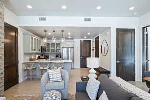Living room with light wood finished floors and recessed lighting