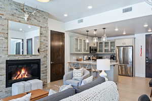 Living room featuring light wood-type flooring, recessed lighting, and a fireplace