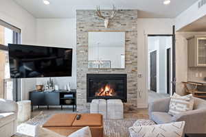 Living area featuring recessed lighting, wood finished floors, and a fireplace