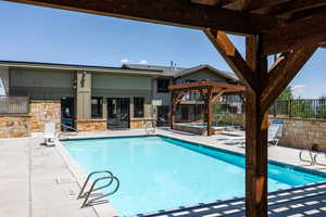 Community pool featuring a pergola, a patio area, a hot tub, and french doors