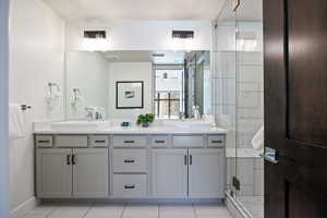 Full bath featuring a shower stall and double vanity