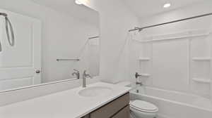 Bathroom with vanity, shower / bathtub combination, and recessed lighting