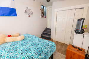 Bedroom with a closet, wood finished floors, and a ceiling fan