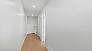 Hallway featuring light wood finished floors and recessed lighting