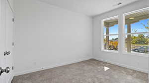 Empty room featuring carpet and baseboards