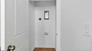 Laundry room with wood finished floors, washer hookup, and hookup for an electric dryer
