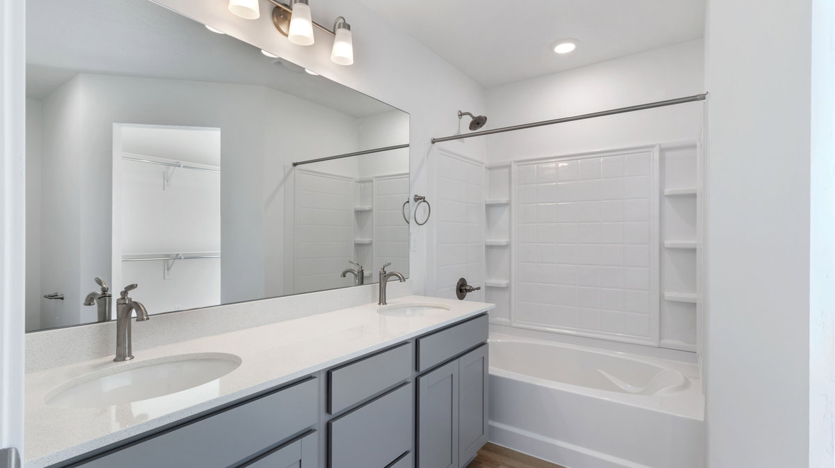 Bathroom with shower / tub combination, double vanity, and recessed lighting