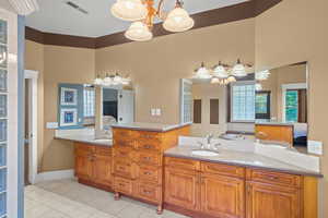 Bathroom with connected bathroom, light tile patterned flooring, and double vanity
