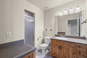 Full bath featuring vanity, light tile patterned floors, and a stall shower