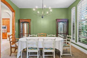 Dining space with arched walkways and a chandelier