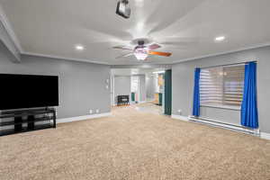 Unfurnished living room featuring crown molding, a baseboard heating unit, light carpet, recessed lighting, and a textured ceiling