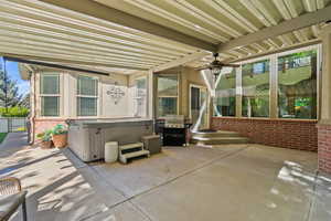 View of patio with a hot tub, ceiling fan, and grilling area