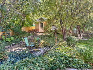 Fenced backyard featuring an outbuilding