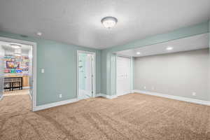 Unfurnished bedroom featuring carpet flooring, a textured ceiling, and a closet