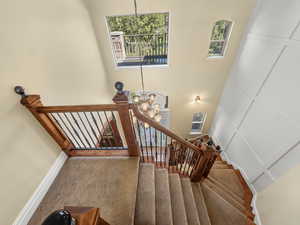 Staircase featuring a chandelier
