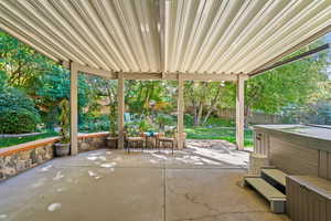Fenced backyard featuring a hot tub and a patio area