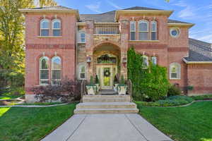 View of front of house with brick siding, a front lawn, and a shingled roof