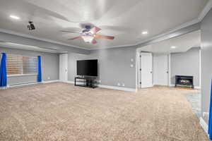 Unfurnished living room with crown molding, recessed lighting, light carpet, a wood stove, and a baseboard heating unit
