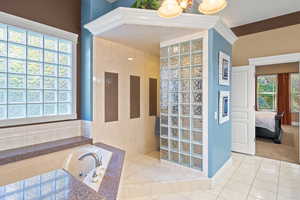 Bathroom featuring a garden tub, a walk in shower, and connected bathroom