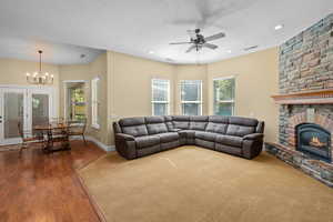 Living room featuring plenty of natural light, a fireplace, wood finished floors, a ceiling fan, and recessed lighting