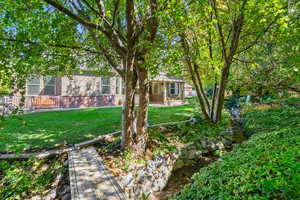 View of green lawn featuring a patio