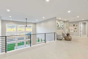 Corridor with carpet, recessed lighting, and an upstairs landing