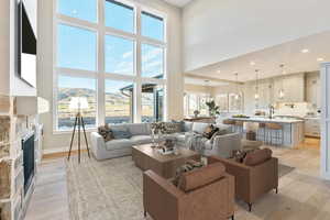 Living area with light wood finished floors, a mountain view, recessed lighting, a towering ceiling, and a fireplace