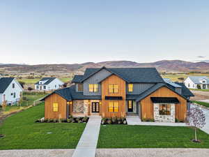 Modern farmhouse with roof with shingles and a front lawn