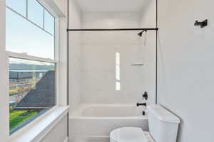 Bathroom featuring toilet and bathtub / shower combination