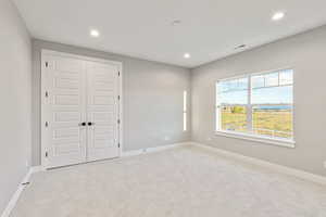 Unfurnished bedroom with carpet flooring, recessed lighting, and a closet