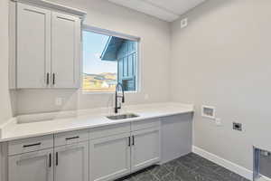Laundry area featuring washer hookup, dark marble finish flooring, electric dryer hookup, and cabinet space