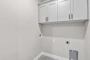 Laundry area featuring hookup for a washing machine, cabinet space, hookup for an electric dryer, and dark wood-style flooring
