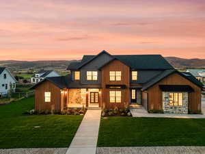 Modern farmhouse with roof with shingles, a front lawn, a mountain view, and board and batten siding