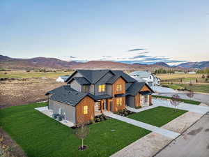 Modern farmhouse style home with a shingled roof, a front yard, and a mountain view