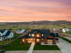 Modern farmhouse style home with concrete driveway, a mountain view, roof with shingles, and board and batten siding