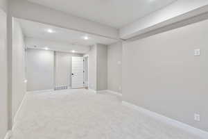 Basement with recessed lighting and light colored carpet