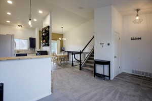 Kitchen with freestanding refrigerator, decorative light fixtures, carpet, light countertops, and decorative backsplash