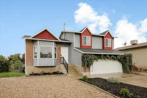 Tri-level home with concrete driveway, a garage, and roof with shingles