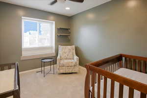 Carpeted bedroom featuring a nursery area, ceiling fan, and recessed lighting