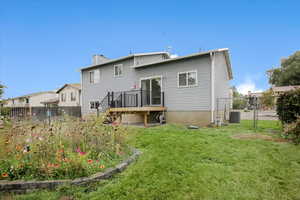 Rear view of property with a fenced backyard, a chimney, a deck, and a gate