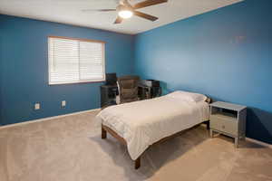 Carpeted bedroom featuring baseboards and a ceiling fan