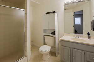 Full bath featuring a stall shower, light tile patterned flooring, and vanity
